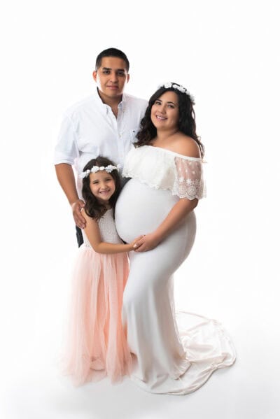 A family posing for a photo in a white studio.