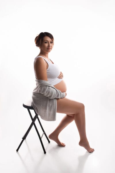 A pregnant woman sitting on a chair.