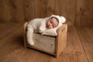 A newborn sleeping in a wooden box.