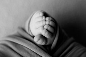 A black and white photo of a baby's feet.