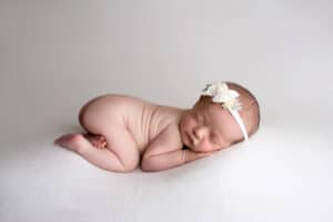 A baby girl sleeping on a white background.