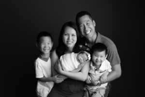 A black and white photo of a family holding a baby.