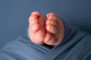 A close up of a baby's feet on a blue blanket.