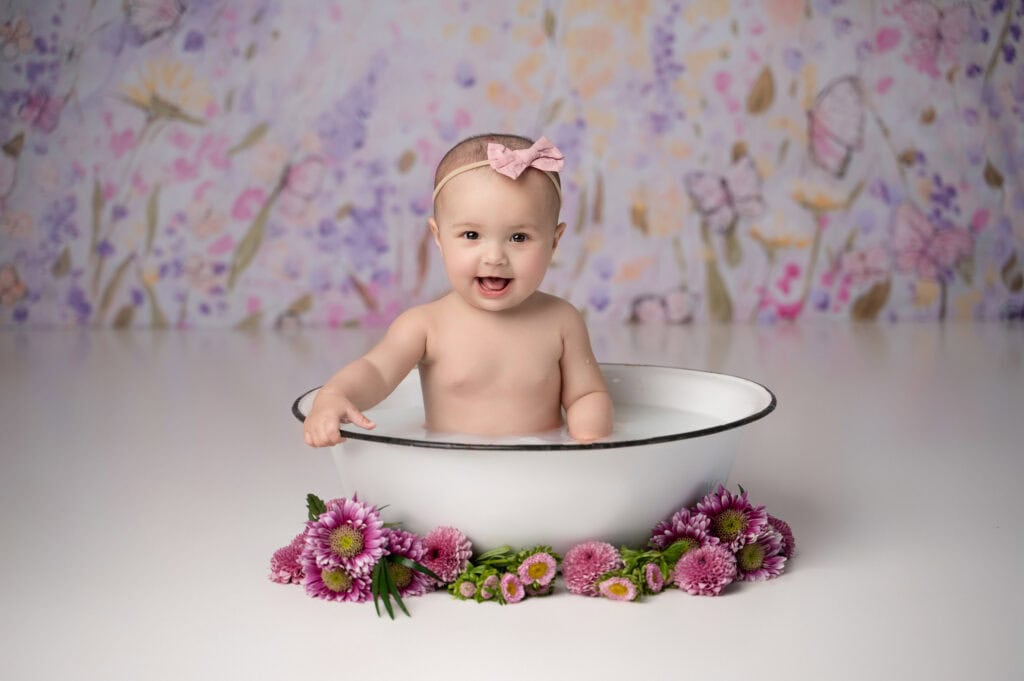 Happy baby in floral bathtub setting