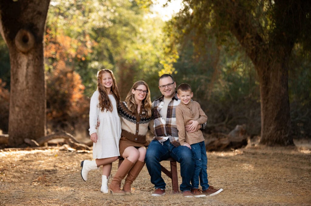 Family sitting outdoors in autumn forest