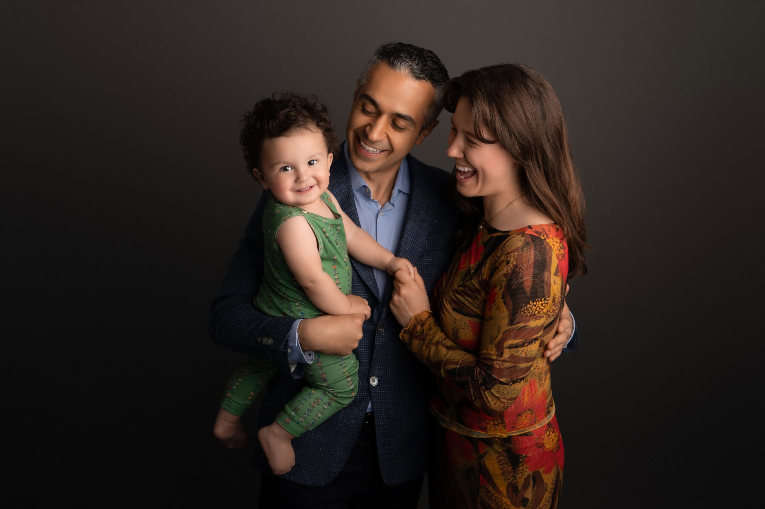 Happy family with smiling baby posing together.