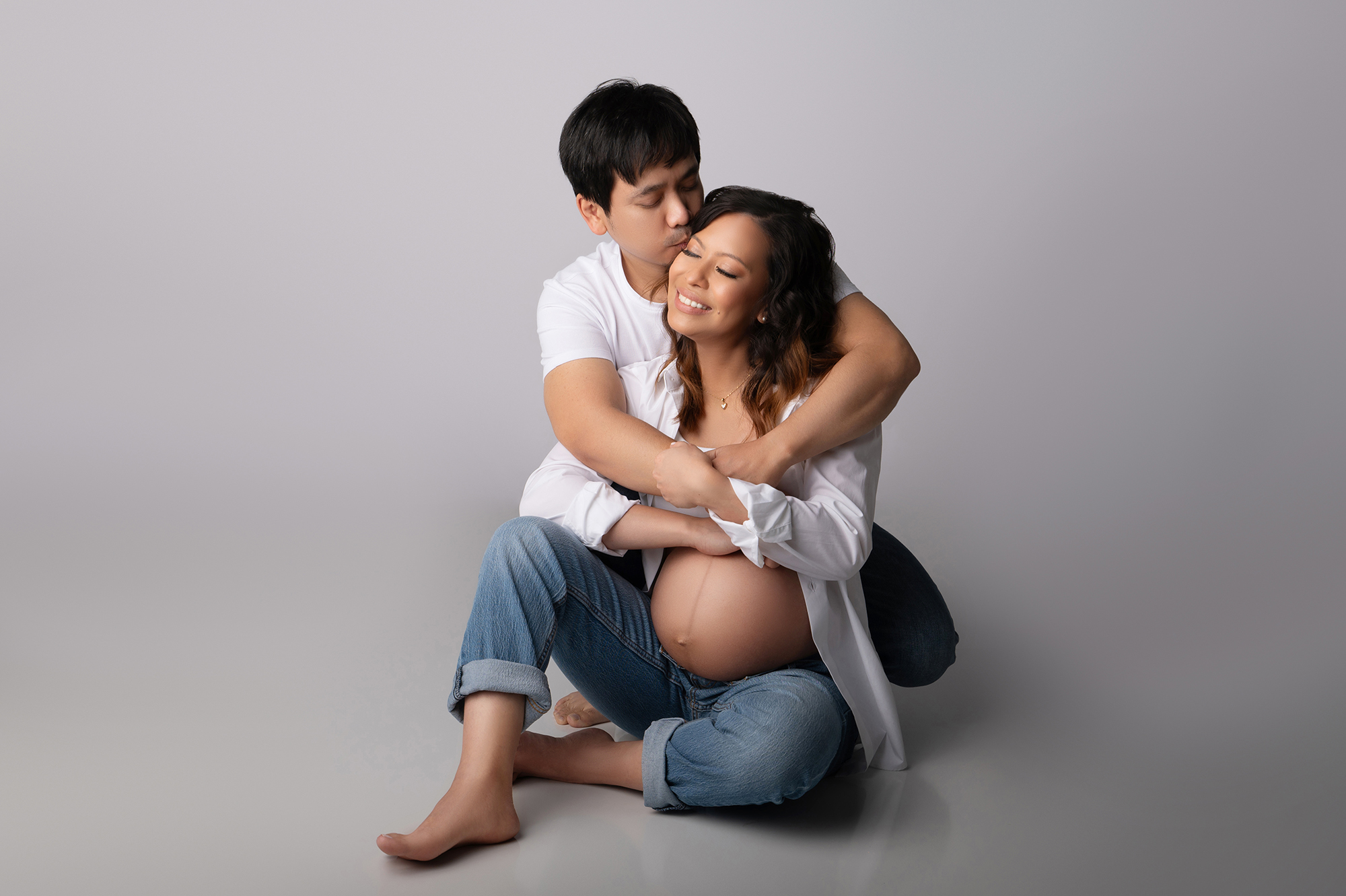 Pregnant couple embracing with joy.