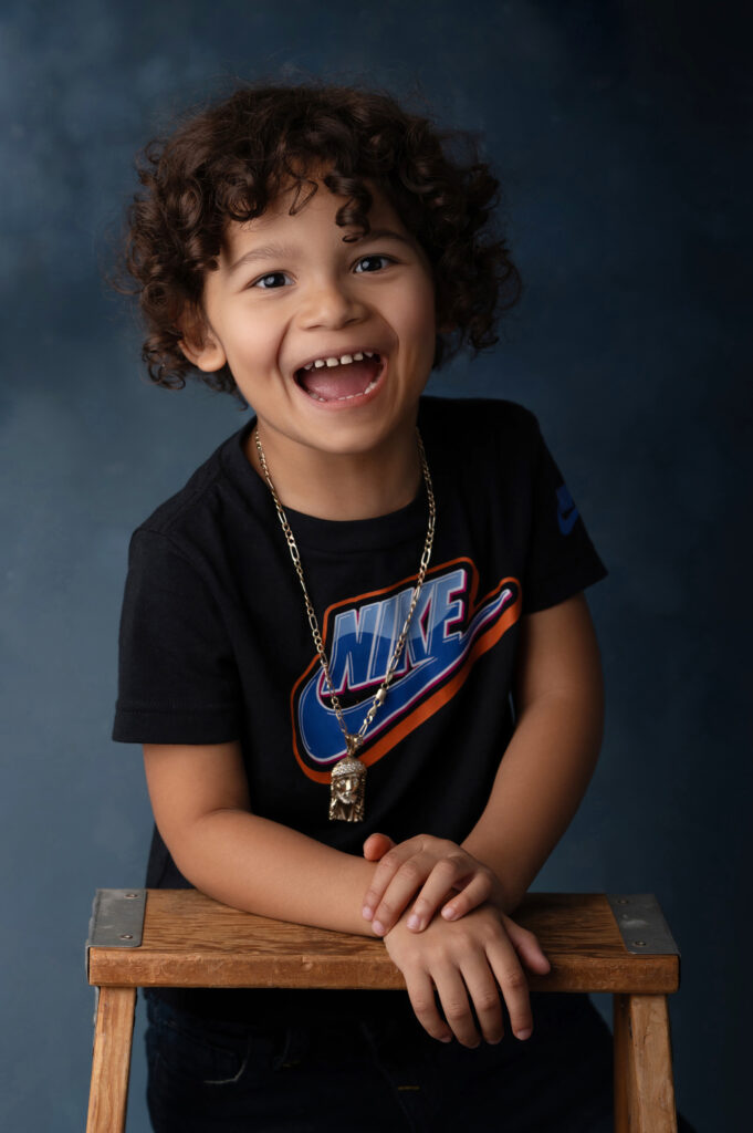 Child smiling widely in Nike shirt.