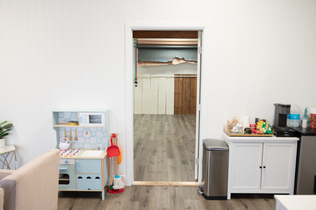 Empty room with kitchenette and open doorway.