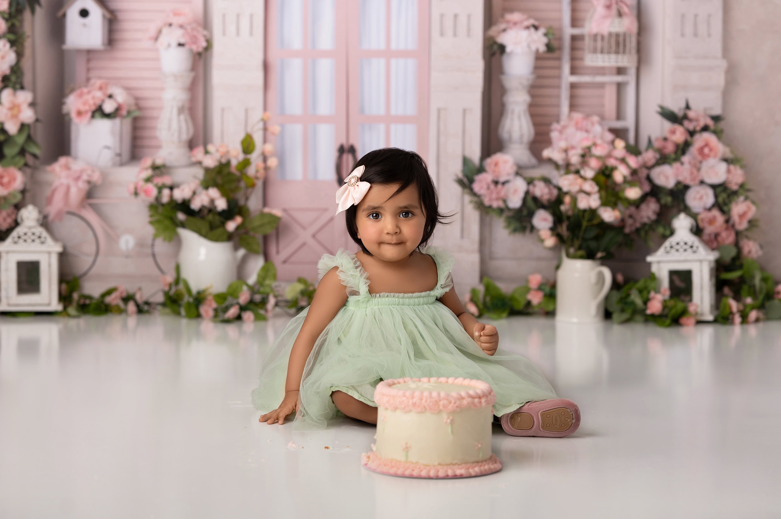 Toddler girl in mint dress with birthday cake