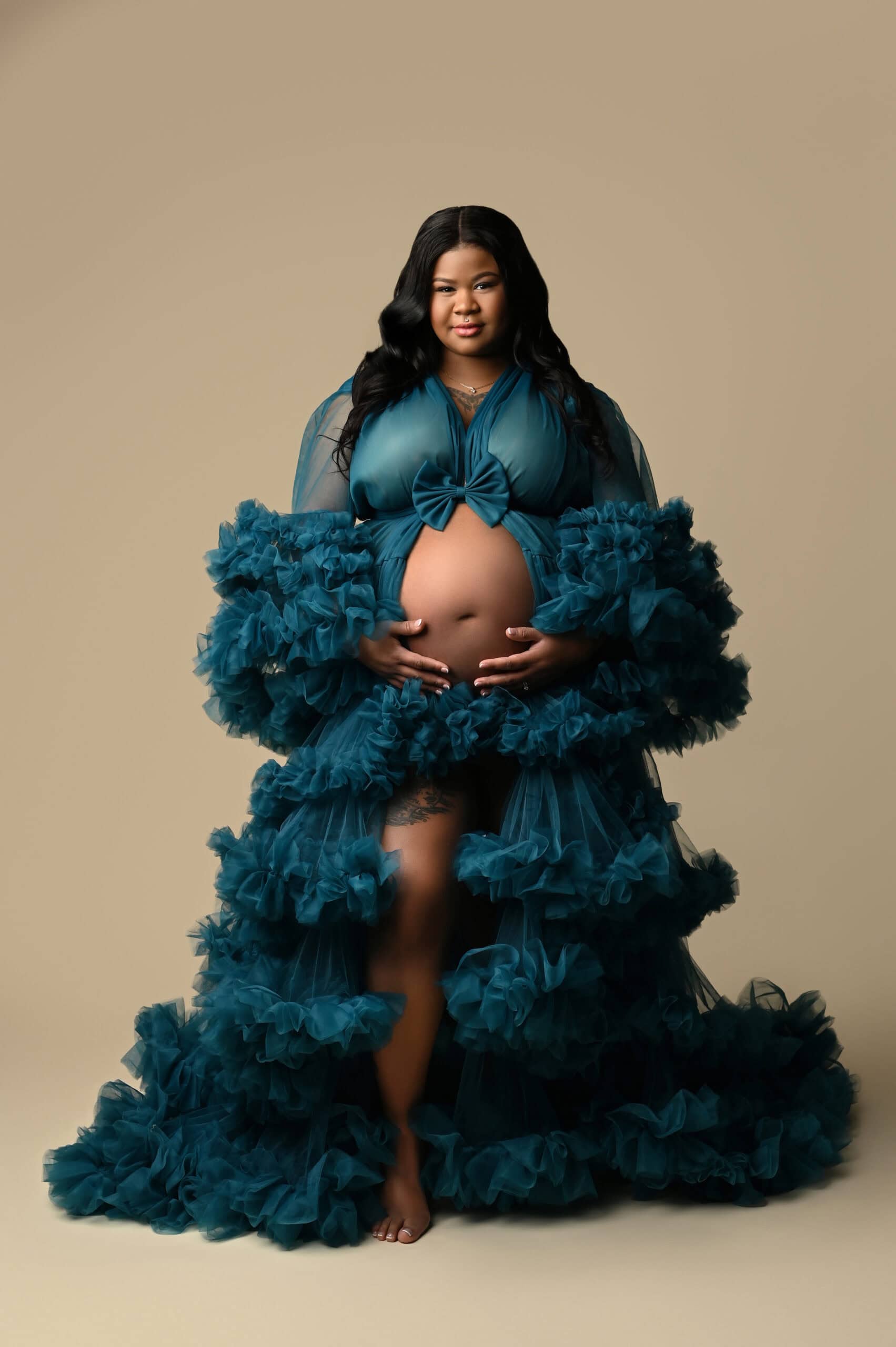 Pregnant woman in teal ruffled maternity gown