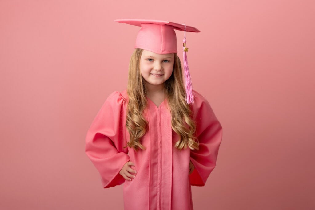 Young girl in pink graduation cap and gown